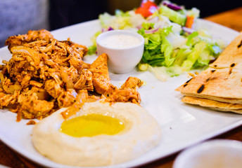 Chargrilled Marinated Chicken with Hummus, Pitta Bread and Salad. Authentic Middle Eastern Food from Restaurant.