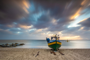 Fishing boat on the beach during sunrise in Gdynia. Baltic Sea. Poland