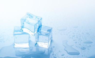 Ice three cubes with drops water clean on blue background