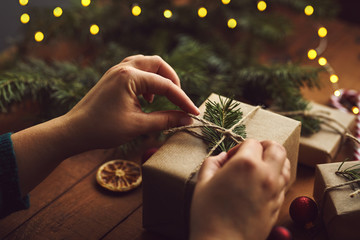 Closeup of female hands packing Christmas gifts