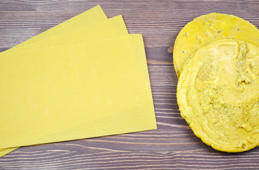 Hand made yellow candles from natural bee wax on a wooden background.