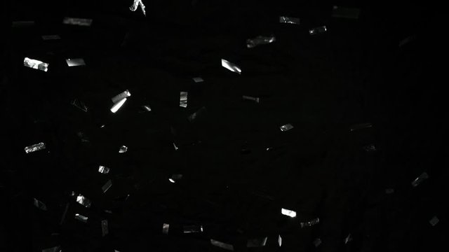 Super slow motion of flying silver confetti isolated on black background. Filmed on high speed cinema camera