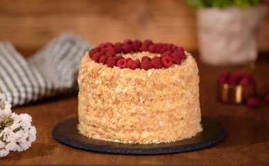 Napoleon layered cake with berries on a wooden table.