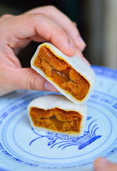 Hand Holding Chinese Snowy Moon cake Showing Fillings Inside. Moon cake is a traditional Chinese food for Middle Autumn Festival.