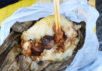 Chopsticks Pick Up Famous Hong Kong Dim Sum "Lo Mai Gai", Glutinous Rice wrapped in Lotus Leaf.
