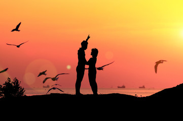 Silhouette couples and sunset light near the sea.