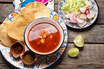 Mexican red pozole on wooden background