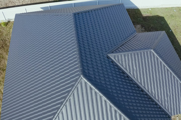 Fototapeta na wymiar House with a gray metal roof. Corrugated metal roof and metal ro