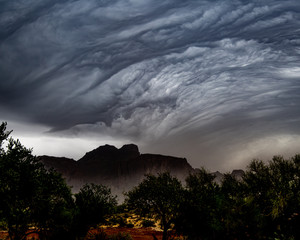 storm clouds rolling over the Superstition Mountains and kicking up a dust storm.