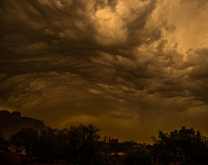 storm clouds rolling over the Superstition Mountains and kicking up a dust storm.