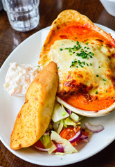 Delicious Lasagna with Tomato Sauce and Finely Chopped Spring Onions. Garlic Bread on Side