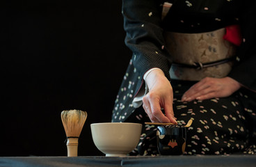 Japanese woman in traditional kimono, during the tea ceremony.