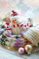  Toy snowman, rat, Christmas decor, warm scarf, illumination on a wooden surface on a window background, decorating the interior for winter seasonal holidays
