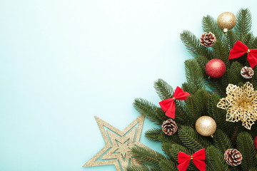 Christmas decoration. Fir-tree branch with gold star, christmas flower and balls on mint
