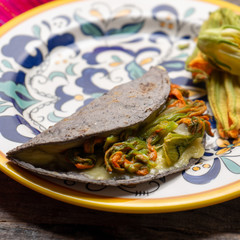Mexican quesadillas with squash blossom on wooden background