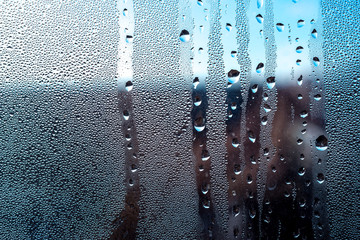 drops of rain water water on a blue glass surface