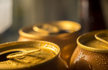 yellow beer cans closeup in cold water droplets