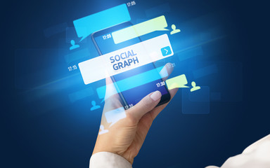 Female hand typing on smartphone with SOCIAL GRAPH inscription, social networking concept