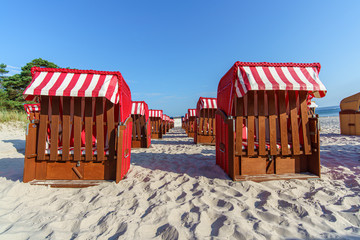 Rote geschlossene  Strandkörbe von vorn im Sand