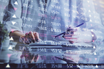 Financial forex graph drawn over hands taking notes background. Concept of research. Double exposure