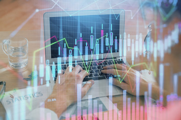 Multi exposure of market chart with man working on computer on background. Concept of financial analysis.