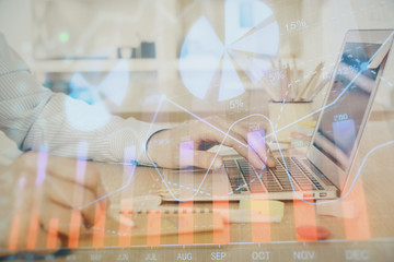 Multi exposure of stock market graph with man working on laptop on background. Concept of financial analysis.