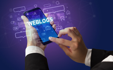 Female hand typing on smartphone with WEBLOGS inscription, social media concept