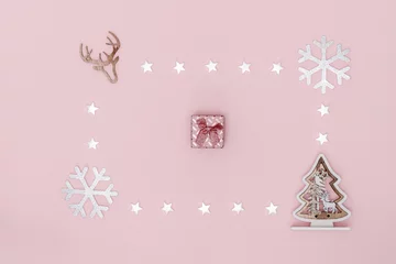 Fototapeten New Year and Christmas composition. Frame from white stars, snowflakes, chrismas tree and gift box on pastel pink background. Top view, flat lay, copy space. © Aisland