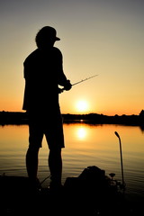 Fishing at the lake at sunset on the boat