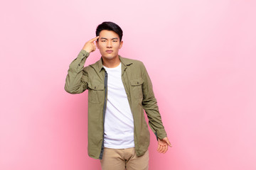 young chinese man feeling confused and puzzled, showing you are insane, crazy or out of your mind...