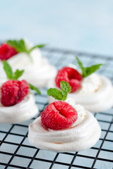 Mini Pavlova meringue with whipped cream and raspberries.