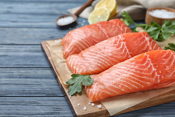 Fresh raw salmon with parsley on blue wooden table. Fish delicacy