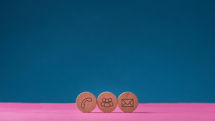 Three wooden cut circles with contact and communication icons