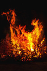 Fototapeta na wymiar Bright big bonfire at night, forks of flame, digital composite