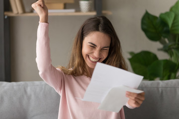Overjoyed young woman feel euphoric reading good news in letter