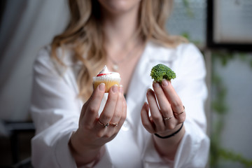 doctor, health care professional, dietitian offering two choices of cup cake or broccoli. Concept...