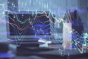 Stock market graph on background with desk and personal computer. Double exposure. Concept of financial analysis.