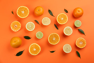 Flat lay composition with tangerines and different citrus fruits on orange background