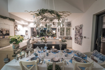 Elegant, beautiful table set for the Christmas dinner together with the family in a modern home