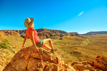 Woman resting after trekking at Ormiston Pound Walk in West MacDonnell Ranges. Mount Sonder lookout, one of highest mountains in Northern Territory, Australia Outback.