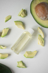 Natural organic avocado oil in a bottle on a light background.