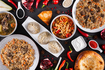 The concept of Eastern asian festive cuisine. Assorted Uzbek food set, pilaf, samsa, lagman, manti, shurpa restaurant concept Eastern arabic new year and Christmas dish from lamb served cookware.