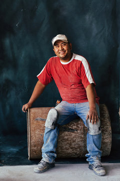 Studio portrait of bricklayer sitting on old barrel in Mexico