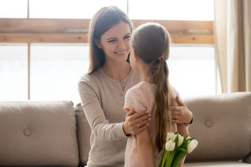 Loving little daughter hide flowers making surprise for mom