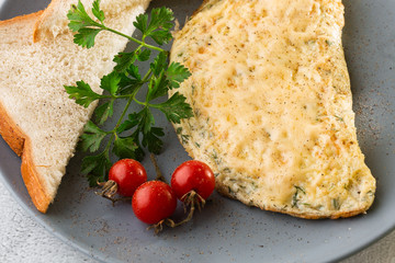 Omelet with cheese, cherry tomatoes and sourdough toast isolated on white marble background. Homemade food. Tasty breakfast. Selective focus. Hotizontal photo.