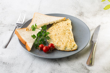 Omelet with cheese, cherry tomatoes and sourdough toast isolated on white marble background. Homemade food. Tasty breakfast. Selective focus. Hotizontal photo.