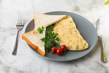 Omelet with cheese, cherry tomatoes and sourdough toast isolated on white marble background. Homemade food. Tasty breakfast. Selective focus. Hotizontal photo.