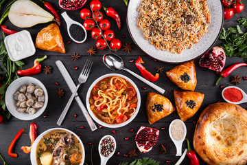 The concept of Eastern asian festive cuisine. Assorted Uzbek food set, pilaf, samsa, lagman, manti, shurpa restaurant concept Eastern arabic new year and Christmas dish from lamb served cookware.