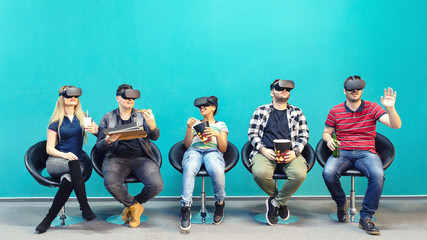 Group of friends using new technology playing on vr glasses indoor – virtual augmented reality...
