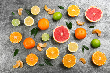Flat lay composition with tangerines and different citrus fruits on grey background